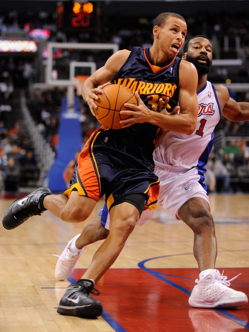 2009: Golden State rookie Stephen Curry drives to the hoop past the Clippers' Baron Davis.