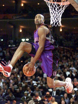 Toronto's Vince Carter passes the ball between his legs as he hangs in the air during the NBA Slam Dunk Contest.