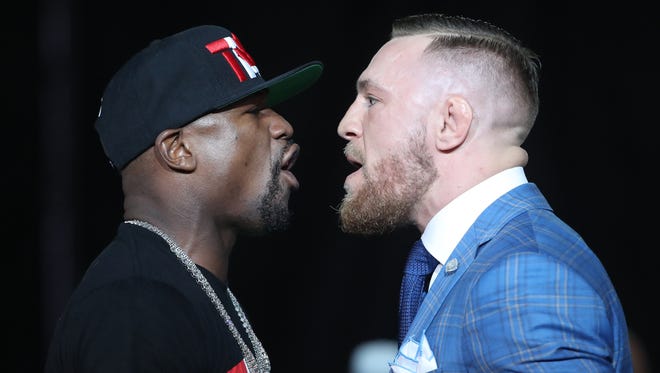 Floyd Mayweather, left, and Conor McGregor jaw at each other during a world tour press conference to promote their fight.