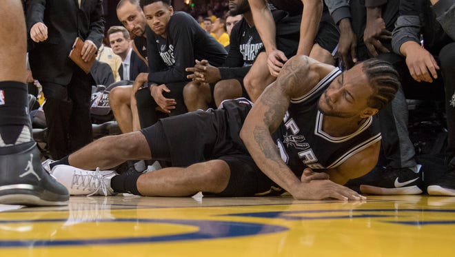 San Antonio Spurs forward Kawhi Leonard (2) reacts after an injury during the third quarter in game one of the Western conference finals of the 2017 NBA Playoffs.