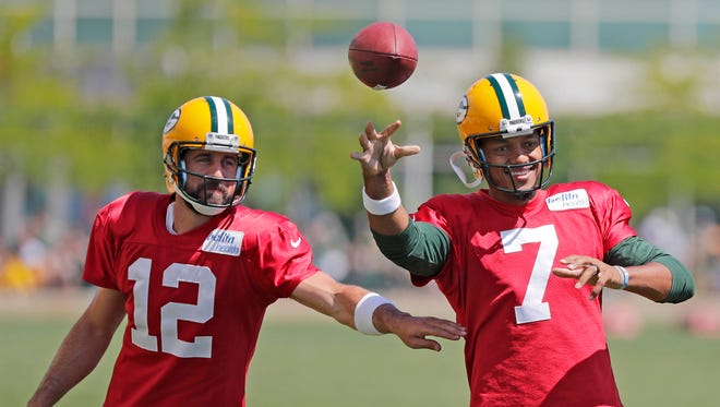 Green Bay Packers quarterback Aaron Rodgers (12) tries to disrupt a throw by quarterback Brett Hundley (7) during ball security drills during training camp at Ray Nitschke Field.