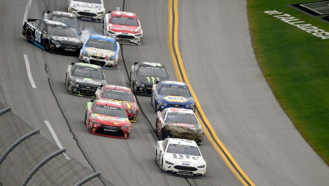 Brad Keselowski, front, leads the pack into the trioval on the final lap of the spring race at Talladega Superspeedway as cars make contact behind him.