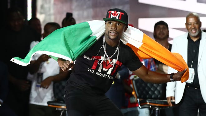 Floyd Mayweather poses with an Irish flag during a world tour press conference to promote the upcoming Mayweather vs McGregor boxing match.