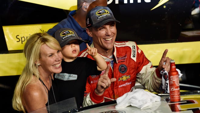 Kevin Harvick, right, celebrates his 2014 NASCAR Sprint Cup championship with wife DeLana Harvick, left, and son Keelan in victory lane.