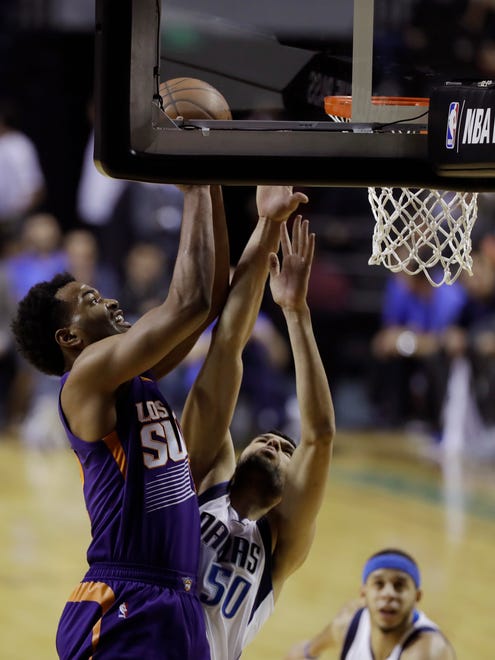 Phoenix Suns TJ Warren, left, tries to score over Dallas Mavericks Salah Mejri in the first half of their regular-season NBA basketball game in Mexico City, Thursday, Jan. 12, 2017.