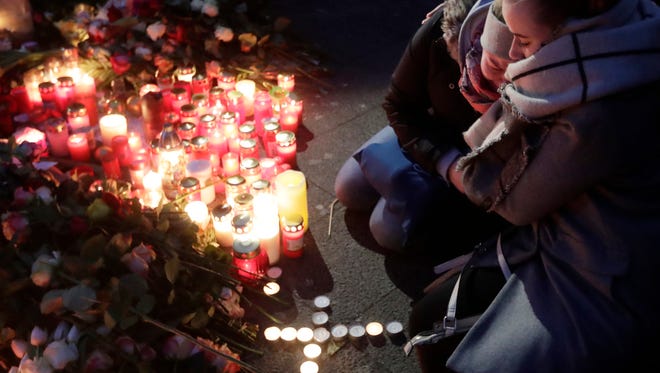 Two women mourn beside candles in Berlin, Germany on Dec. 20, 2016.