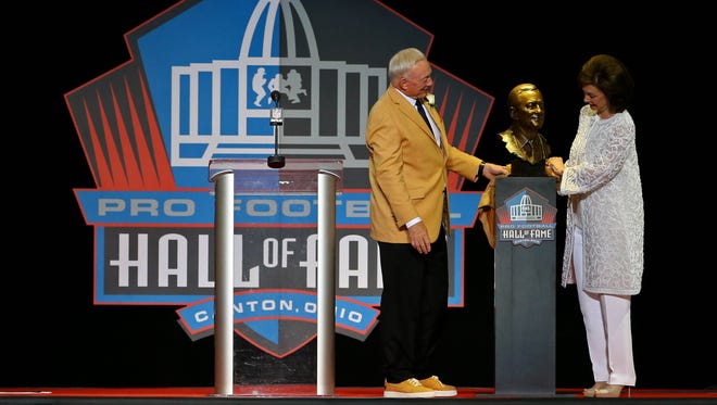 Jerry Jones pulls back the cloth on his bust with his wife Gene Jones (right) during the 2017 Pro Football Hall of Fame enshrinement at Tom Benson Hall of Fame Stadium.
