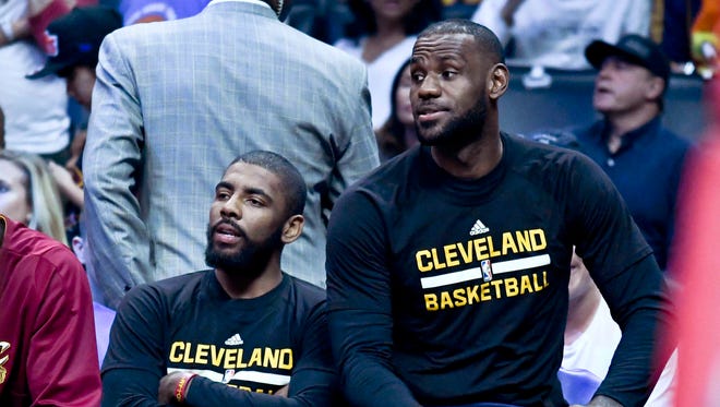 Cleveland Cavaliers guard Kyrie Irving and forward LeBron James on the bench during the first half of a NBA game against the LA Clippers at the Staples Center.
