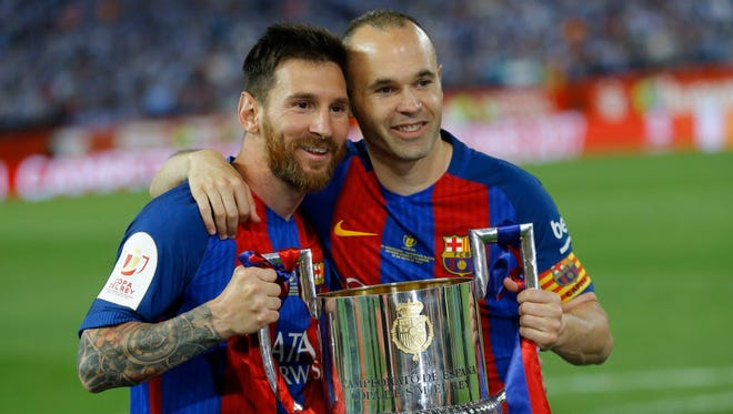 Barcelona's Lionel Messi and Andres Iniesta pose with the trophy after the Copa del Rey final soccer match between Barcelona and Alaves.