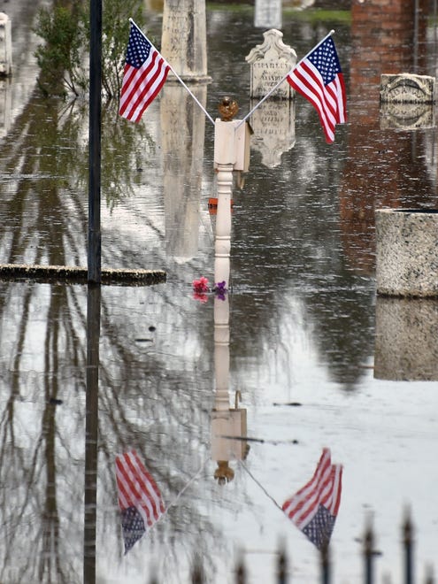 American flags set on a grave reflect in the water of the flooded Marysville Cemetery downstream from the Oroville Dam.