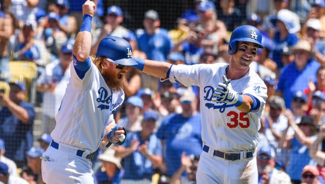 Los Angeles Dodgers left fielder Cody Bellinger (35) celebrates his third inning two run homer against the Colorado Rockies with third baseman Justin Turner (10) at Dodger Stadium.