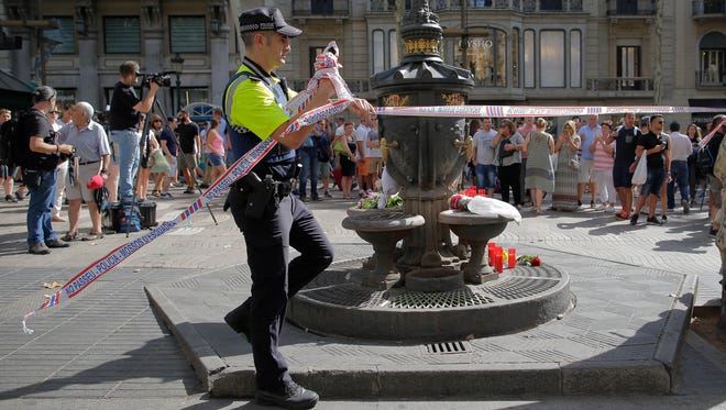 A police officer removes police tape in Barcelona on Aug. 18, 2017.