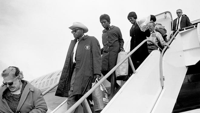 Tennessee A&I State University coach Ed Temple, center, and Tigerbelles sprinters Wyomia Tyus, behind Temple, and Edith McGuire walk off the plane after arriving from Tokyo at the Nashville Municipal Airport Oct. 28, 1964. In the Olympic games in Tokyo, McGuire won the gold in the 200-meters and Tyus picked up gold in the 100-meter dash.