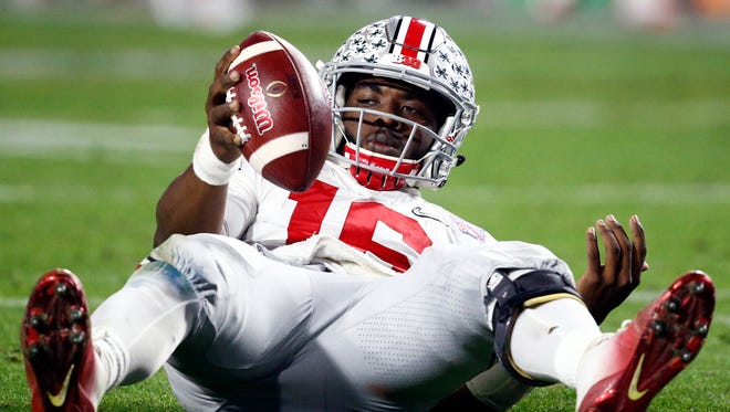 Ohio State quarterback J.T. Barrett looks to the bench after being sacked again.