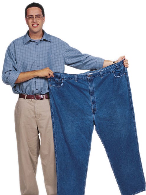 Photos taken of Jared Fogle known as the Subway guy after the diet as he holds up the pants he use to wear before his diet.