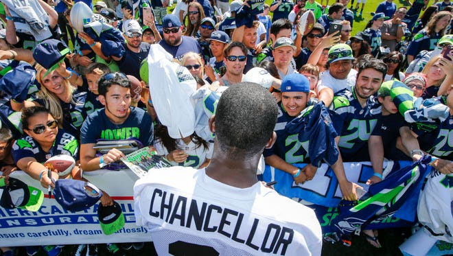 Seattle Seahawks strong safety Kam Chancellor (31) signs autographs following training camp at the Virginia Mason Athletic Center.