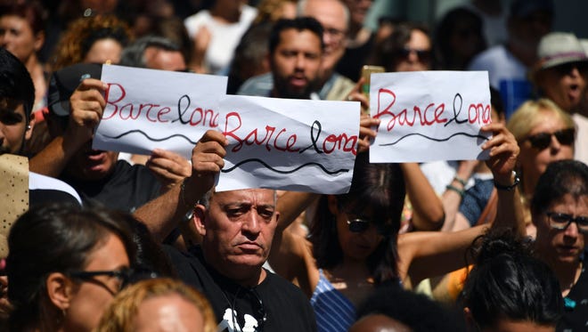 People hold written signs before observing a minute of silence for the victims of the Barcelona attack at Plaza de Catalunya on Aug. 18, 2017, a day after a van plowed into the crowd, killing 14 persons and injuring over 100 on the Rambla in Barcelona, Spain.