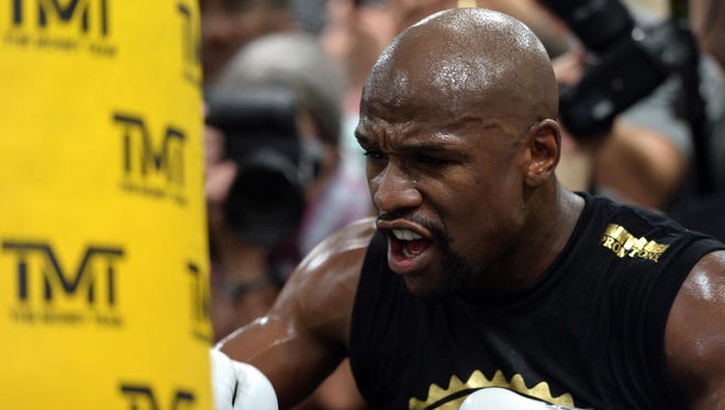 Floyd Mayweather Jr. hits a heavy bag during a media workout in preparation for his fight against Conor McGregor at Mayweather Boxing Club.