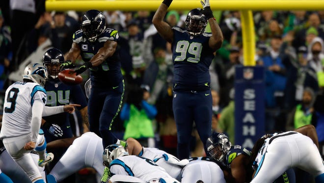 Kam Chancellor #31 of the Seattle Seahawks blocks Graham Gano #9 of the Carolina Panthers but gets called for roughing the kicker in the second quarter during the 2015 NFC Divisional Playoff game at CenturyLink Field on January 10, 2015 in Seattle, Washington.