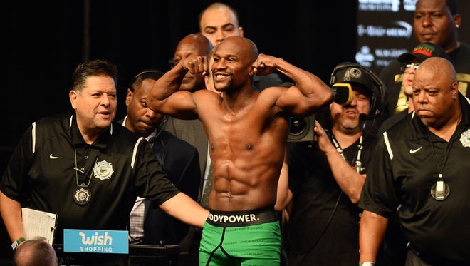 Floyd Mayweather Jr.  weighs in for his upcoming boxing match against Conor McGregor (not pictured) at T-Mobile Arena.