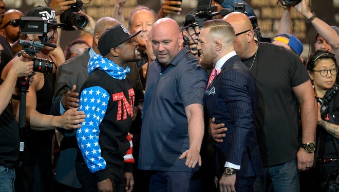 Floyd Mayweather and Conor McGregor meet face to face as UFC President Dana White keeps them separated following the world tour press conference to promote the upcoming Mayweather vs McGregor boxing match.