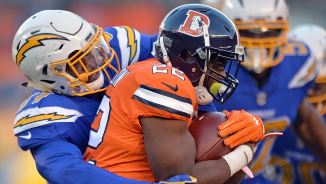 Denver Broncos running back C.J. Anderson (22) is tackled by San Diego Chargers inside linebacker Denzel Perryman (52) during the first quarter at Qualcomm Stadium.