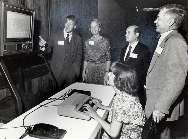 In 1980, The Dispatch became the first newspaper available by home computer through CompuServe. Here, CompuServe CEO Jeffrey M. Wilkins, left, explains a technical point to Katharine Graham of the Washington Post, John F. Wolfe and David L. Bowen, while CompuServe's Jill Gates enters a command on a electronic terminal.