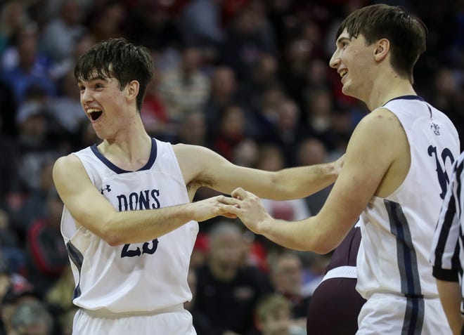 Columbus Catholic High School's Cy Becker (25) and Lucas Kreklau (10) celebrate after a whistle near the end of the game against Solon Springs High School in a Division 5 semifinal game during the WIAA state boys basketball tournament on Friday, March 15, 2024 at the Kohl Center in Madison, Wis. Columbus Catholic won the game, 78-65.