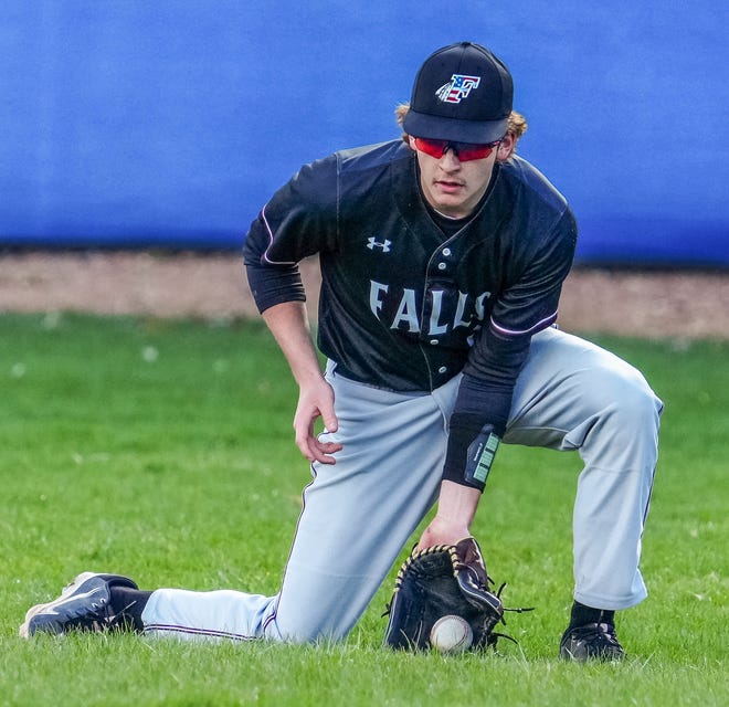 Menomonee Falls right fielder Jordan Hedrick (9) scoops up a ground ball during the game at Germantown, Friday, April 12, 2024.