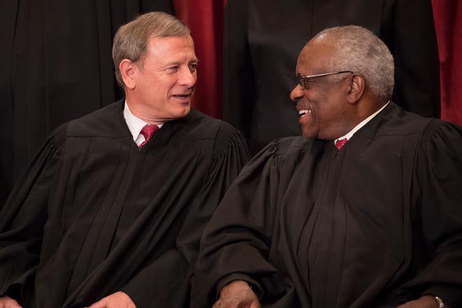 Chief Justice of the United States John G. Roberts and Associate Justice Clarence Thomas speak during a group photo of all nine Supreme Court Justices on June 1, 2017.
